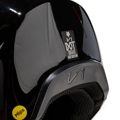 Capacete preto brilhante com etiquetas 'V1 DOT' e adesivo amarelo 'Mips'.