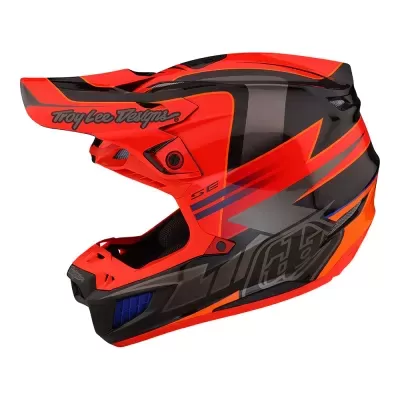 Capacete integral de motocross laranja, preto e cinza com texto 'Troy Lee Designs' e 'SE'.