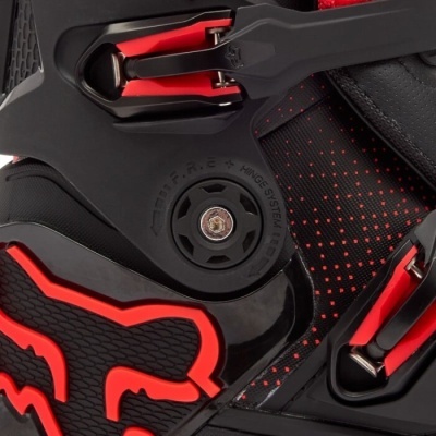 Close-up de equipamento desportivo preto e vermelho com roda e partes metálicas
