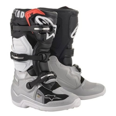 Botas de motocross cinza, preto, branco e vermelho com fivelas metálicas e marca ALPINESTARS.