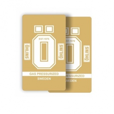 Cartelas retangulares bege com texto branco ÖHLINS e informações sobre gás pressurizado