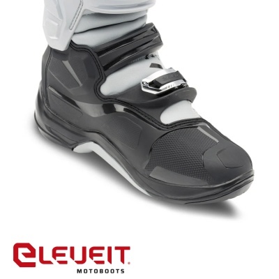Bota de moto preta e cinza com fecho metálico e detalhes texturizados.