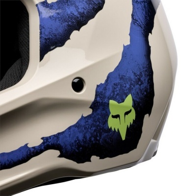 Parte lateral de capacete branco com padrão azul e logo raposa verde