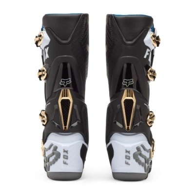 Botas de motocross pretas e brancas com detalhes dourados e logótipo FOX vistas de trás