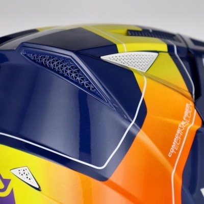 Capacete colorido com entradas de ar e texto impresso em plástico brilhante