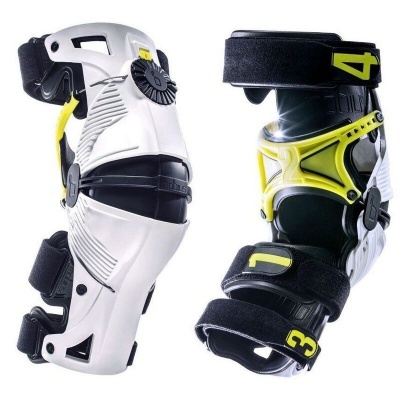 Par de joelheiras desportivas brancas e pretas com detalhes amarelos e números 3 e 4