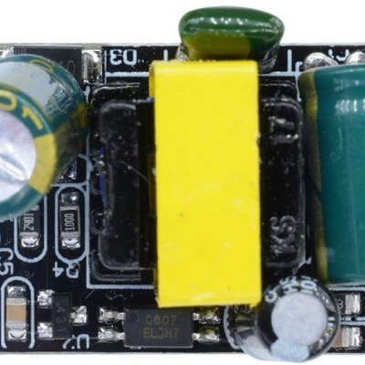 Placa eletrónica com condensadores, transformador amarelo e componentes variados