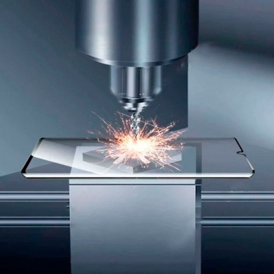 Máquina a gravar a laser num metal prateado com faíscas