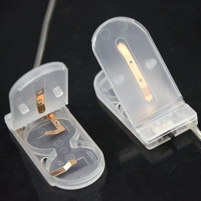 Clipes de plástico translúcido com contactos metálicos sobre superfície preta