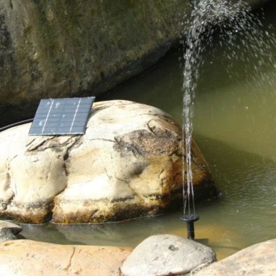 Bomba de água para jardim com painel solar numa lagoa com pedras