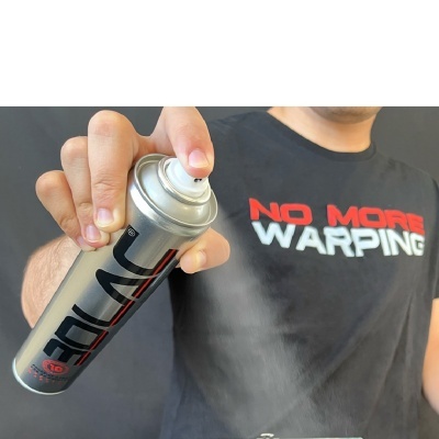 Spray em lata metálica prateada a ser pulverizado por pessoa com t-shirt preta escrita NO MORE WARPING.