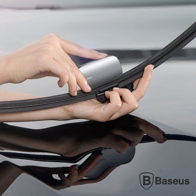 Mão a instalar limpa-vidros Baseus preto e cinza em para-brisas de carro preto