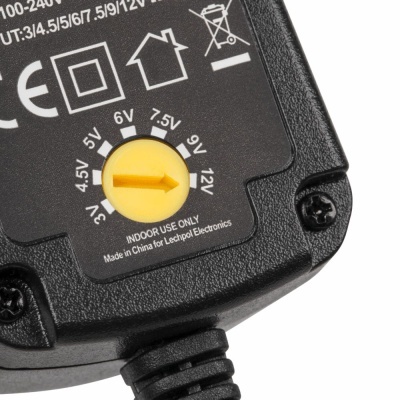 Transformador elétrico preto com botão amarelo para seleção de voltagem