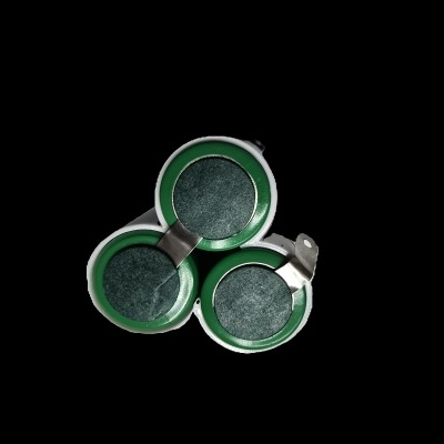 Três cápsulas de café verdes com partes metálicas, em fundo preto