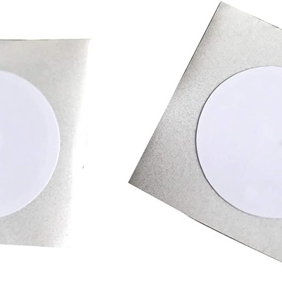 Dois adesivos redondos brancos com fundo cinzento quadrado