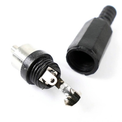 Conector elétrico metálico e plástico preto sobre fundo branco