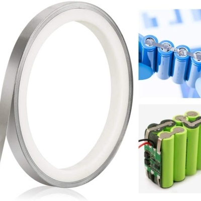 Fita metálica em rolo, pilhas azuis alinhadas e conjunto de pilhas verdes ligadas com fios e circuito