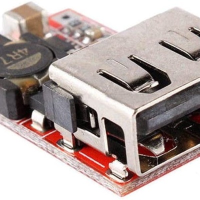 Placa eletrónica vermelha com conector USB metálico prateado e componentes eletrónicos