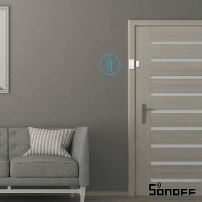 Porta interior de madeira clara com sofá cinzento e almofada listrada junto a ela