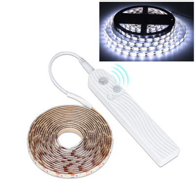 Fita LED enrolada e controlo remoto branco com sensor de movimento e botões em fundo branco
