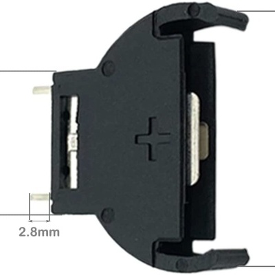 Porta-pilha redondo preto com terminal metálico e polaridade '+'.