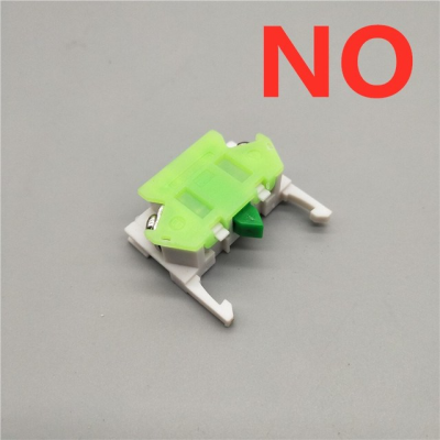 Peça plástica verde e branca com texto vermelho NO