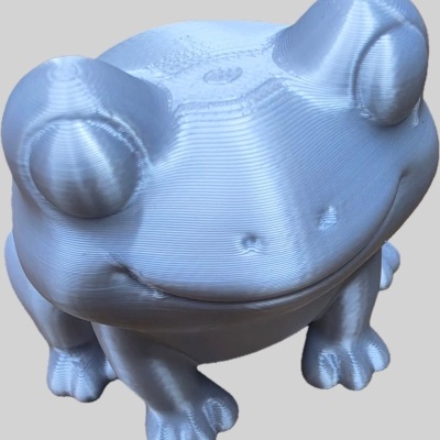 Figura de rã prateada com textura em linhas horizontais