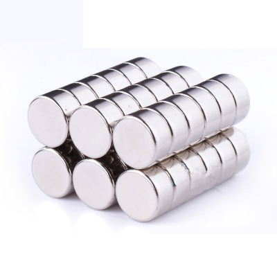 Ímanes redondos de neodímio empilhados em filas sobre fundo branco