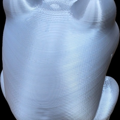 Objeto 3D branco com textura de linhas, forma arredondada com orelhas e pés