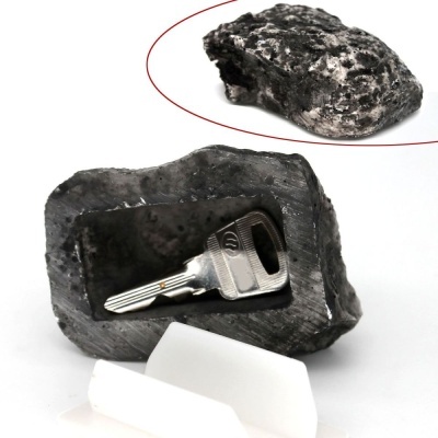 Caixa oculta de pedra preta com chave metálica no interior