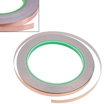 Fita adesiva fina metálica cor de cobre com interior verde enrolada em círculo