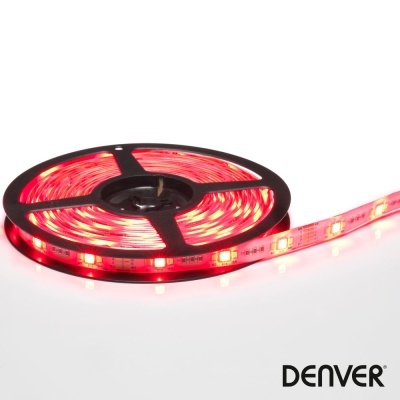 Tira de LED roja enrollada sobre una placa negra con LEDs encendidos y fondo blanco.