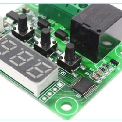 Placa eletrónica verde com botões pretos e display digital