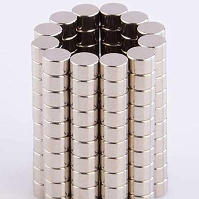 Pequenos ímanes cilíndricos prateados empilhados em colunas em círculo
