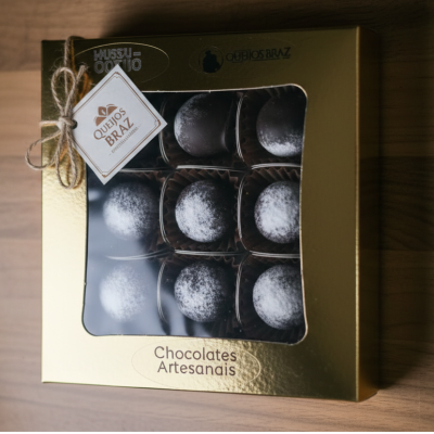 Caixa dourada com chocolates artesanais e etiqueta QUEIJOS BRAZ
