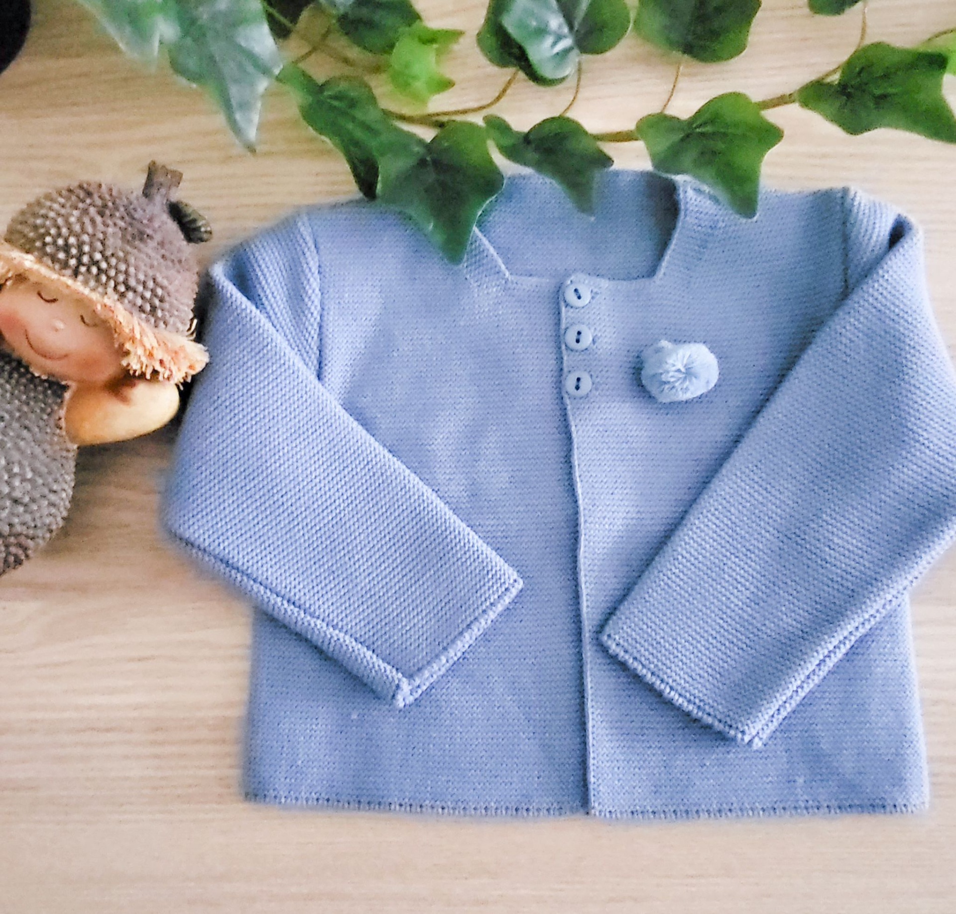 Camisola de bebé azul claro de malha com botões e pompom