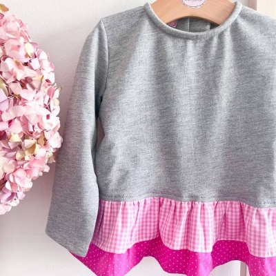 Camisola cinza com barra rosa e cabide de madeira