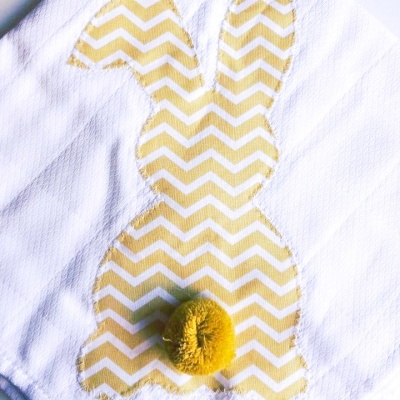 Toalha branca com coelho em tecido amarelo e branco ziguezague e pompom amarelo