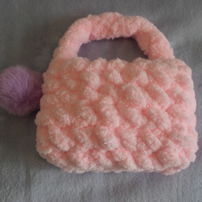 Bolsa rosa felpuda com pompom roxo e textura bolha