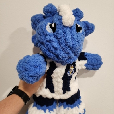Pelúcia azul e branca felpuda com camisa listrada e emblema colorido
