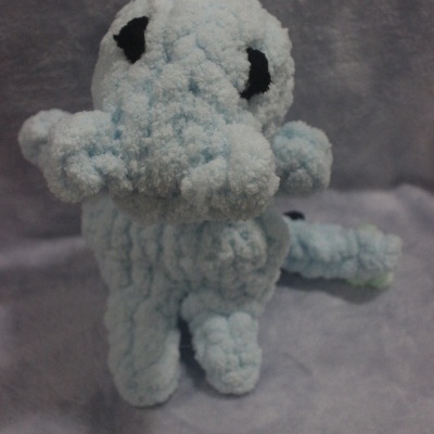 Boneco de croché azul claro com detalhes em azul e preto