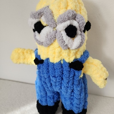 Pelúcia artesanal tipo Minion em tecido felpudo amarelo e azul.
