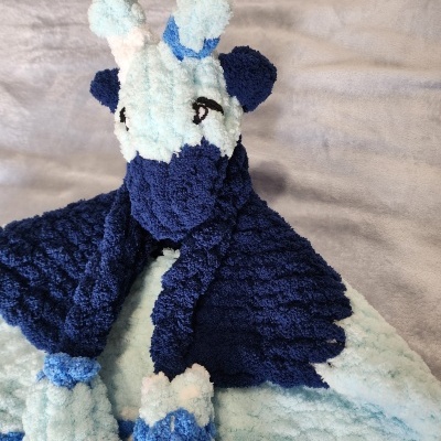 Pelúcia azul e branca em forma de girafa com padrão texturizado