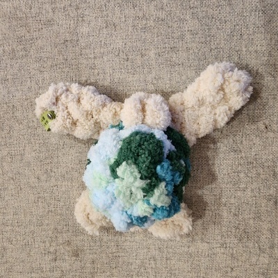 Peluche colorido de pompons e tecido bege de fundo