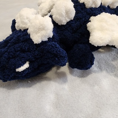 Pantufas felpudas azul escuro com pompons brancos sobre fundo cinzento
