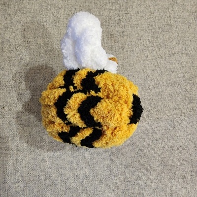 Gorro de malha amarelo com riscas pretas e topo branco com etiqueta.