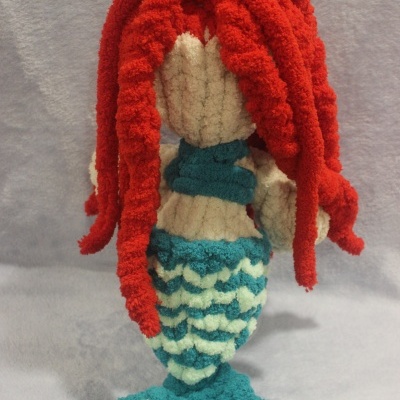 Boneco de croché de sereia com cabelo vermelho e cauda azul turquesa