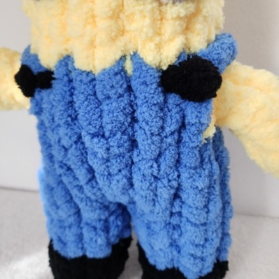 Boneco de pelúcia com roupa azul e amarela e textura felpuda