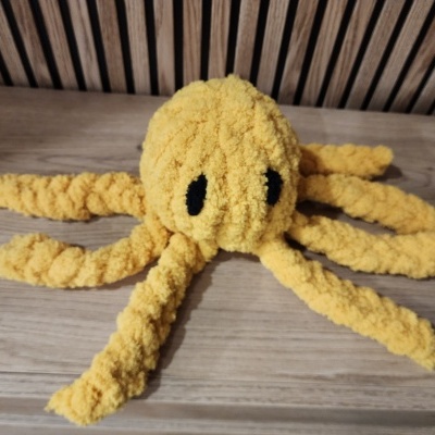 Pelúcia de polvo amarelo sobre mesa de madeira.