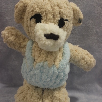 Ursinho de pelúcia bege com roupa azul clara